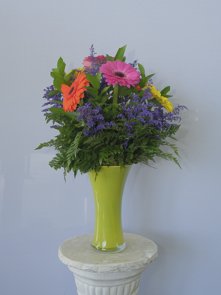 Yellow vase with orange pink and purple flowers